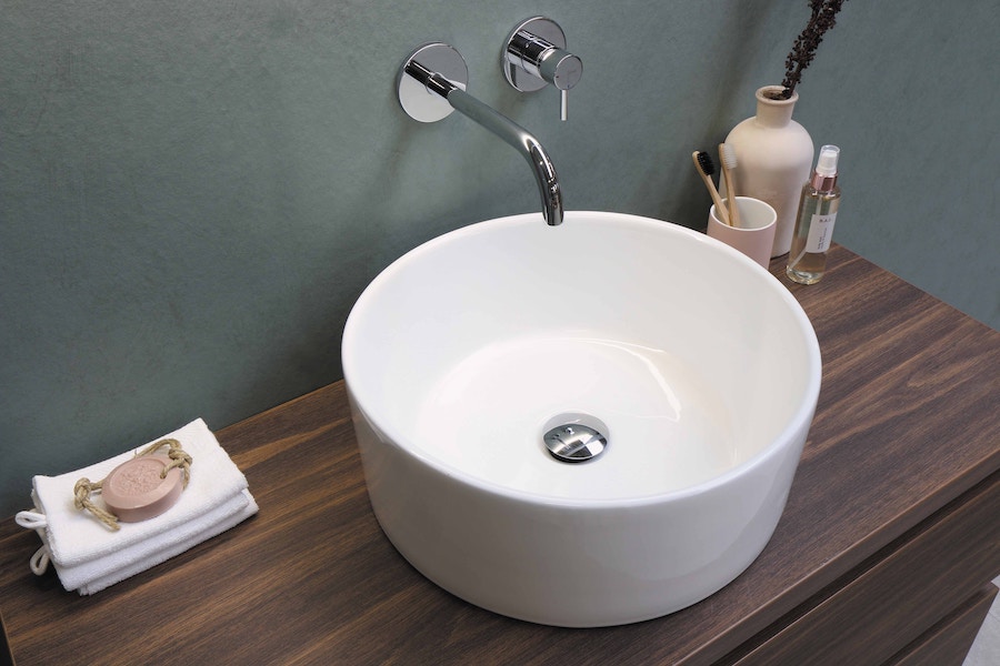 A white sink with a tap, bathroom furniture, fixtures and fittings.