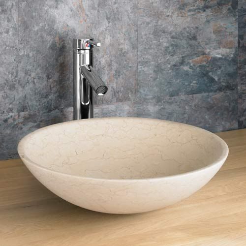 A cream limestone basin with a stainless steel tap