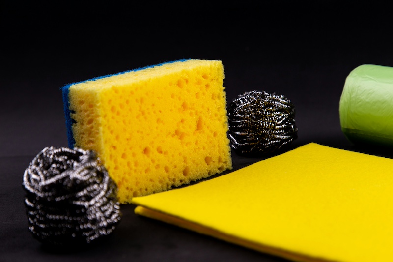 A collection of bathroom cleaning products including a sponge and scouring pads