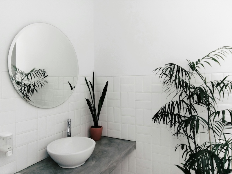 White minimalistic bathroom with a circular mirror and round basin